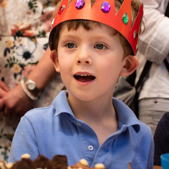 boy with a red coloured crown on his head