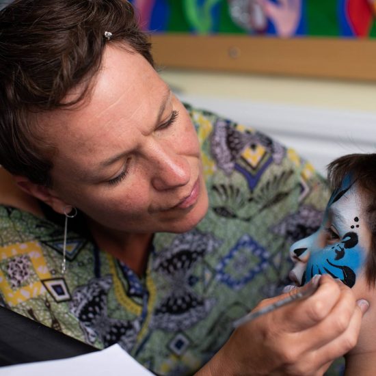 child having face paint added to his face