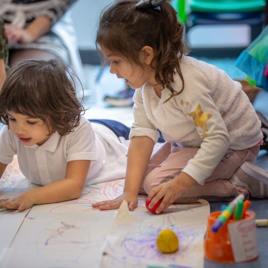 children colouring in sheets of paper