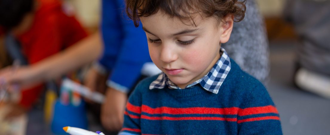 boy looking at a coloured pen