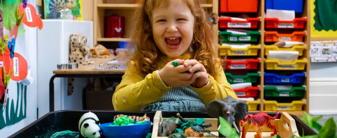 laughing girl with zoo animal toys