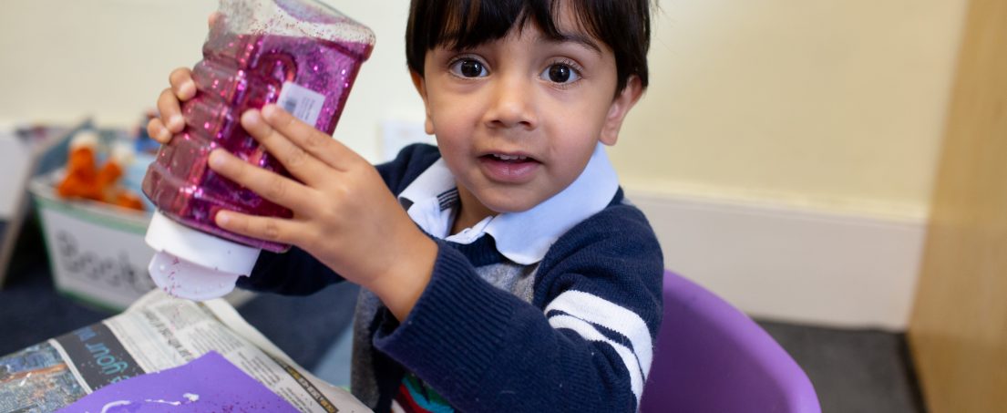 boy holding a plastic container with pink glitter