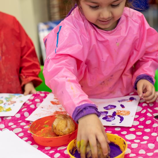 girl using a potato to paint