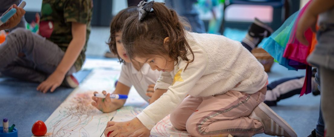 girls colouring on pieces of paper