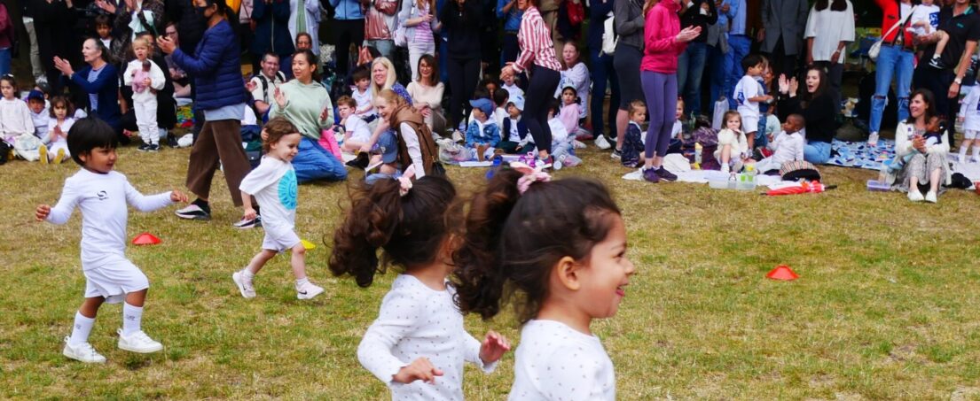 children playing in the field with their parents